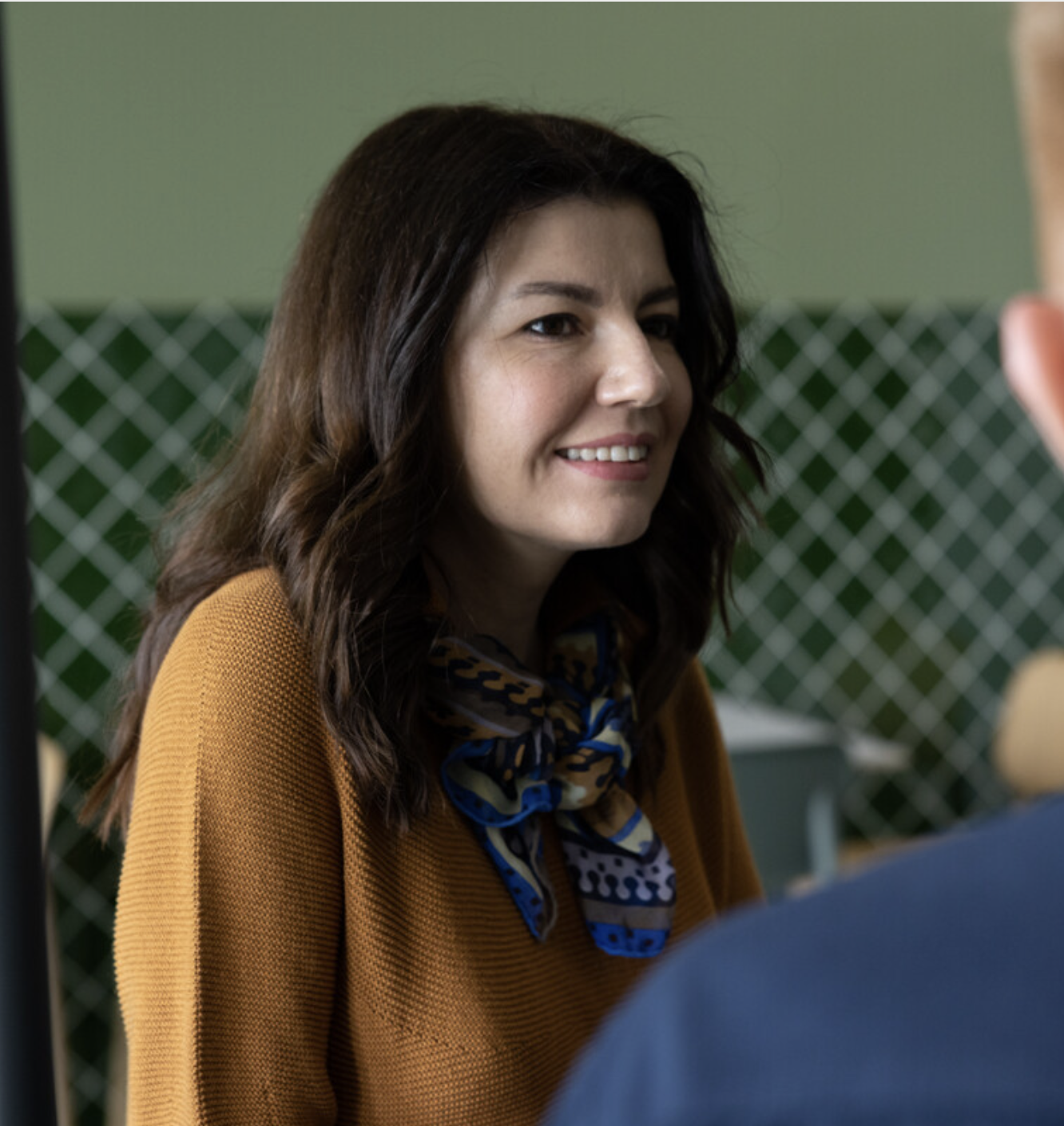 smilende dame ved et bord