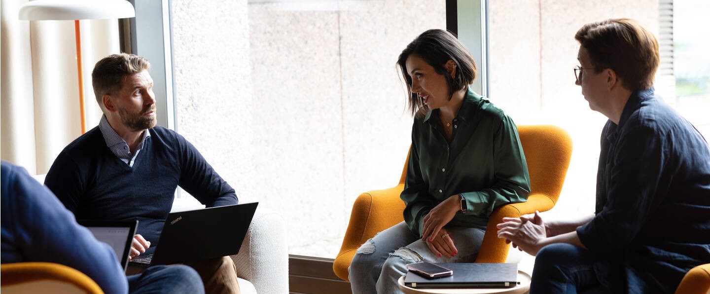 two women and man in a meeting discussion